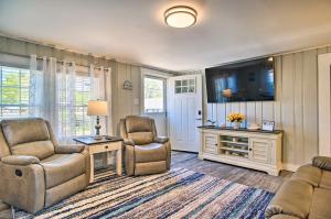 a living room with two chairs and a tv at Wareham Cottage with Deck, Walk to Swifts Beach in Wareham