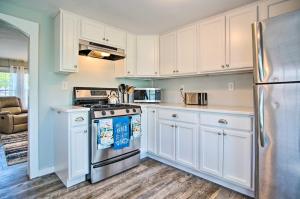 a kitchen with white cabinets and stainless steel appliances at Wareham Cottage with Deck, Walk to Swifts Beach in Wareham