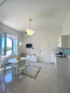 una cucina e una sala da pranzo con tavolo e sedie di Residence Villa Giordano a Vietri