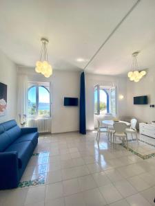 a living room with a blue couch and a table at Residence Villa Giordano in Vietri sul Mare