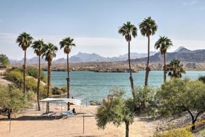 a beach with palm trees and a body of water at Lake Havasu City Home with Private Beach, Dock! in Lake Havasu City