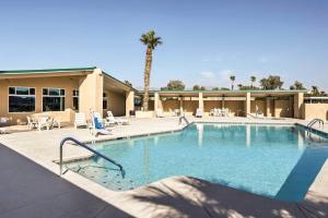 a large swimming pool with chairs and a building at Dock and Beach Access Cozy Lake Havasu City Home! in Lake Havasu City