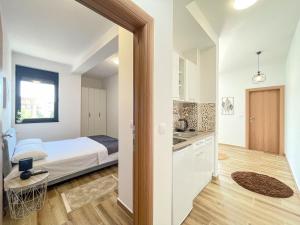 a small bedroom with a bed and a kitchen at MaNora in Ulcinj