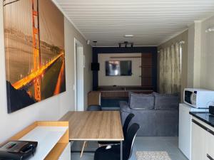 a kitchen and living room with a table and a couch at Apartamento aconchegante próximo Capivari in Campos do Jordão
