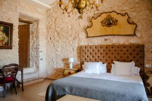 a bedroom with a bed and a chandelier at Finca Gomera - Agroturismo Hotel in Cala Pi +94 photos