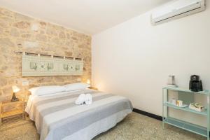 um quarto com uma cama com dois sapatos brancos em LA TORRE DEI COLOMBO em Baunei