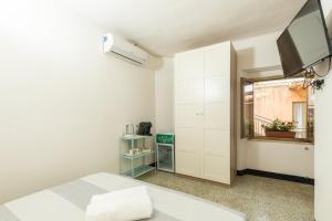 um quarto com uma cama e uma televisão na parede em LA TORRE DEI COLOMBO em Baunei