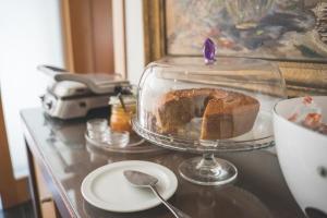 ein Kuchen in einer Glasschale auf einem Tisch in der Unterkunft Hotel De Cerva in Cerva