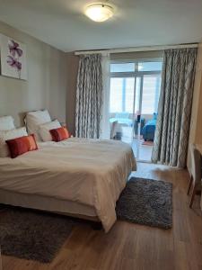 um quarto com uma cama grande e uma janela grande em Beach Hive 1 em Swakopmund