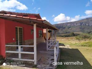 a red house with a staircase in front of it at Pouso do Elefante in Serra do Cipo