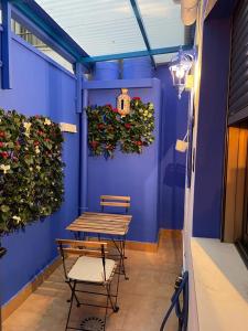 a blue wall with a table and chairs and plants at Apartamento El Azul in Molina de Segura