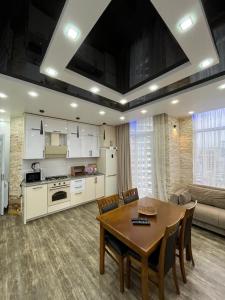 a kitchen and dining room with a table and chairs at Apartament DeLux Sea View in Batumi