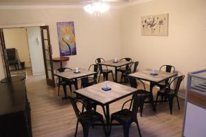 a room with tables and chairs in a restaurant at La Capucine in Kroonstad