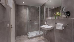 een badkamer met een douche en een wastafel bij Hotel Unique Pearl in Dortmund