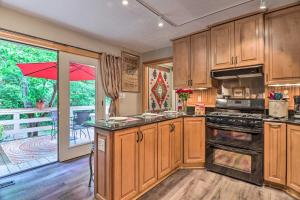 a large kitchen with wooden cabinets and a balcony at Quiet Art-Inspired Hendersonville Boutique Lodge! in Hendersonville
