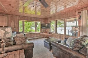 a living room with leather couches and a television at Lakefront Gloversville Home with Beach and Dock! in Broadalbin