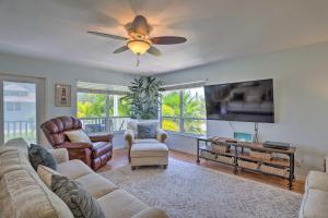 a living room with a couch and a flat screen tv at Covered Deck and Bay Views Bradenton Beach Abode! in Bradenton Beach