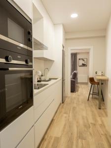 cocina con armarios blancos y encimera en Vivienda con Fines turísticos "San Bartolomé", en Andújar