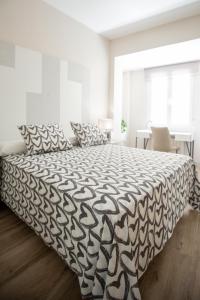 a bedroom with a bed with a black and white comforter at Vivienda con Fines turísticos "San Bartolomé" in Andújar