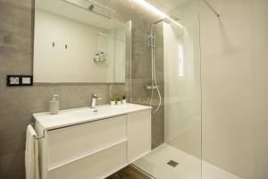 a white bathroom with a sink and a shower at Vivienda con Fines turísticos "San Bartolomé" in Andújar +34 photos