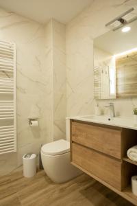 a white bathroom with a toilet and a sink at Vivienda con Fines turísticos "San Bartolomé" in Andújar