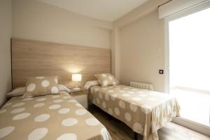 a small bedroom with two beds and a window at Vivienda con Fines turísticos "San Bartolomé" in Andújar