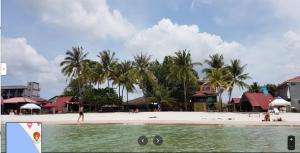 a beach with palm trees and people on it at Sandy Beach Resort By Casa Loma in Pantai Cenang
