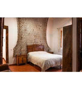 a bedroom with a bed and a wall at Casa rural luciano in Malagón