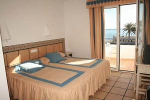 Virgen del Mar Holidays في موجاكار: غرفة نوم مع سرير وإطلالة على المحيط