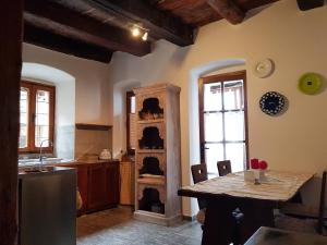 a kitchen with a table and a shelf with dishes at La Baita di Francesca in Rido