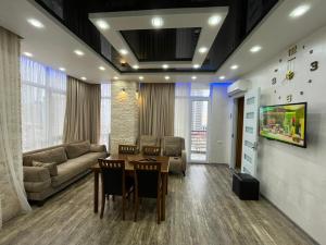 a living room with a table and a couch at Apartament DeLux Sea View in Batumi