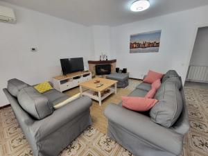 un soggiorno con 2 divani e una TV di Torredembarra cosy, well equipped house, 5 min. from the beach a Torredembarra