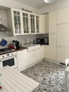 a kitchen with white cabinets and a sink at Casa Bonelli in Sestri Levante
