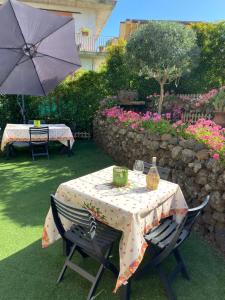 un tavolo e sedie con ombrellone in giardino di Etna Vintage a Linguaglossa