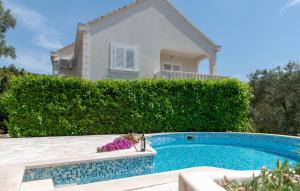 a villa with a swimming pool in front of a house at Apartments Valeria in Korčula