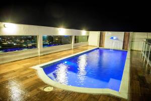 a large swimming pool in the middle of a building at Hotel Arujá in Arujá