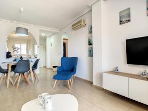 salon z telewizorem i niebieskimi krzesłami w obiekcie Ribera Beach 1 - 2906 w mieście Mar de Cristal