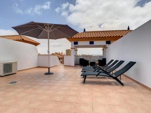 patio z krzesłami i parasolem na dachu w obiekcie Ribera Beach 1 - 2906 w mieście Mar de Cristal