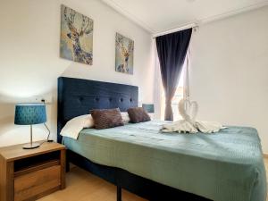 sypialnia z niebieskim łóżkiem i oknem w obiekcie Ribera Beach 1 - 2906 w mieście Mar de Cristal