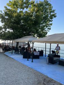 a group of people sitting under umbrellas near the water at Villa Maria Carmela in Briatico