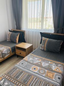 a bedroom with two beds and a table and a window at Apart Angel Suit 3 in Nevşehir