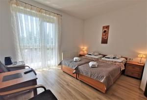 a bedroom with two beds and a large window at Przedsiębiorstwo Turystyczne "SOL" in Grzybowo