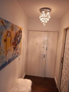 um quarto com uma pintura na parede e um lustre em Parisian Sparkle Retreat em Neuilly-sur-Seine