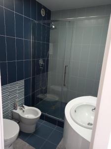 uma casa de banho com um WC, um lavatório e um chuveiro em Parisian Sparkle Retreat em Neuilly-sur-Seine
