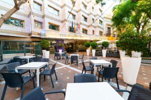 une terrasse d'un restaurant avec des tables et des chaises dans l'établissement Torreluz Centro, à Almería