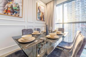 uma sala de jantar com uma mesa de vidro e cadeiras em Spacious Art Deco Apt with Burj & Canal Views no Dubai