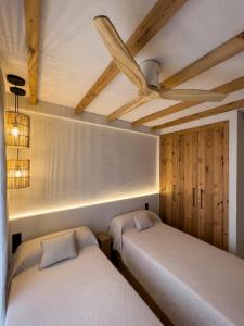 2 łóżka w pokoju z drewnianym sufitem w obiekcie Casa La Marina - Zahara de los Atunes w mieście Zahara de los Atunes