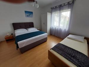 1 dormitorio con 2 camas y ventana en Apartments Ana en Grebaštica