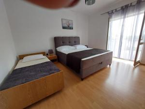 1 dormitorio con 2 camas y ventana grande en Apartments Ana en Grebaštica