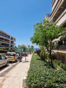 una acera con un árbol al lado de un edificio en Arman Group Lannister, en Atenas